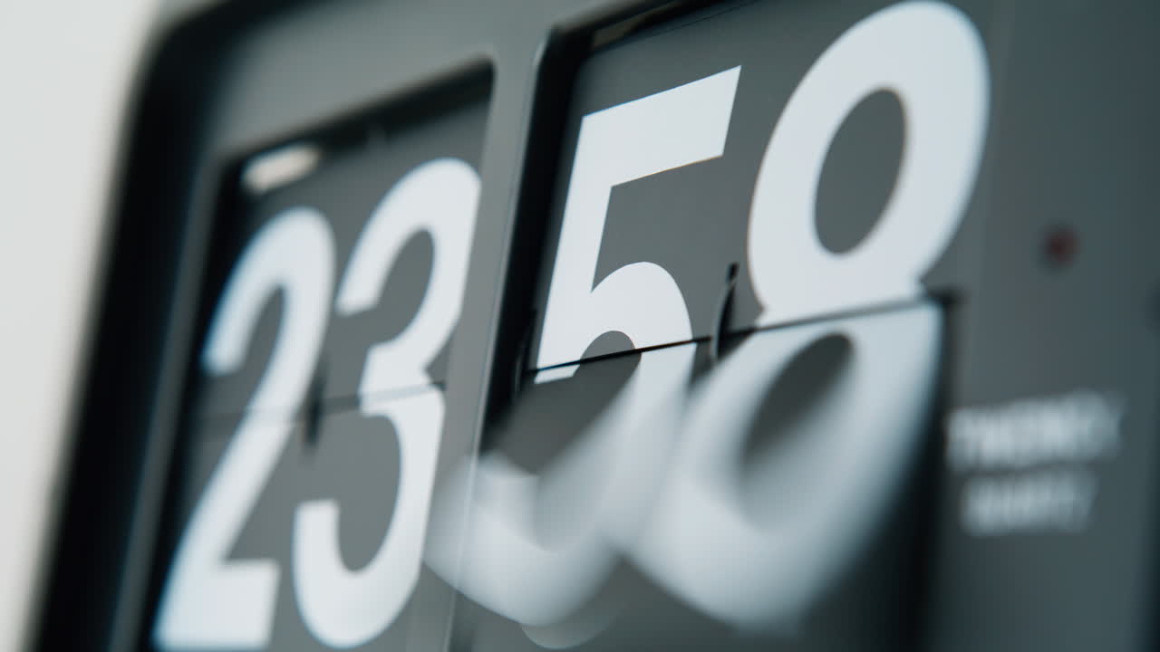 Clock display flipping downward marking passage of time indoors closeup