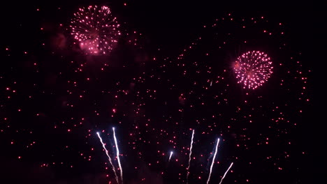 fuegos artificiales rojos brillantes explotan en el cielo nocturno