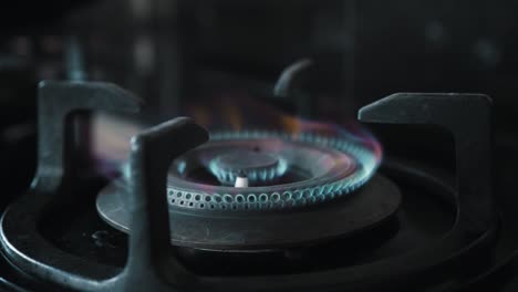 video of a black gas stove with blue and red burning flame in the kitchen