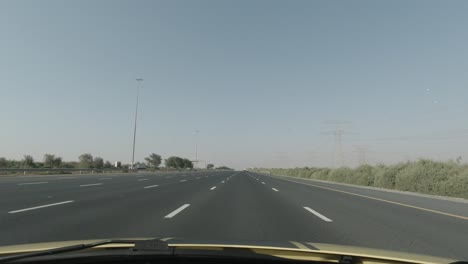 solar powered street lights in the middle of desert freeway with 6 lane roads on both sides can be seen with high electrical towers on the right side.