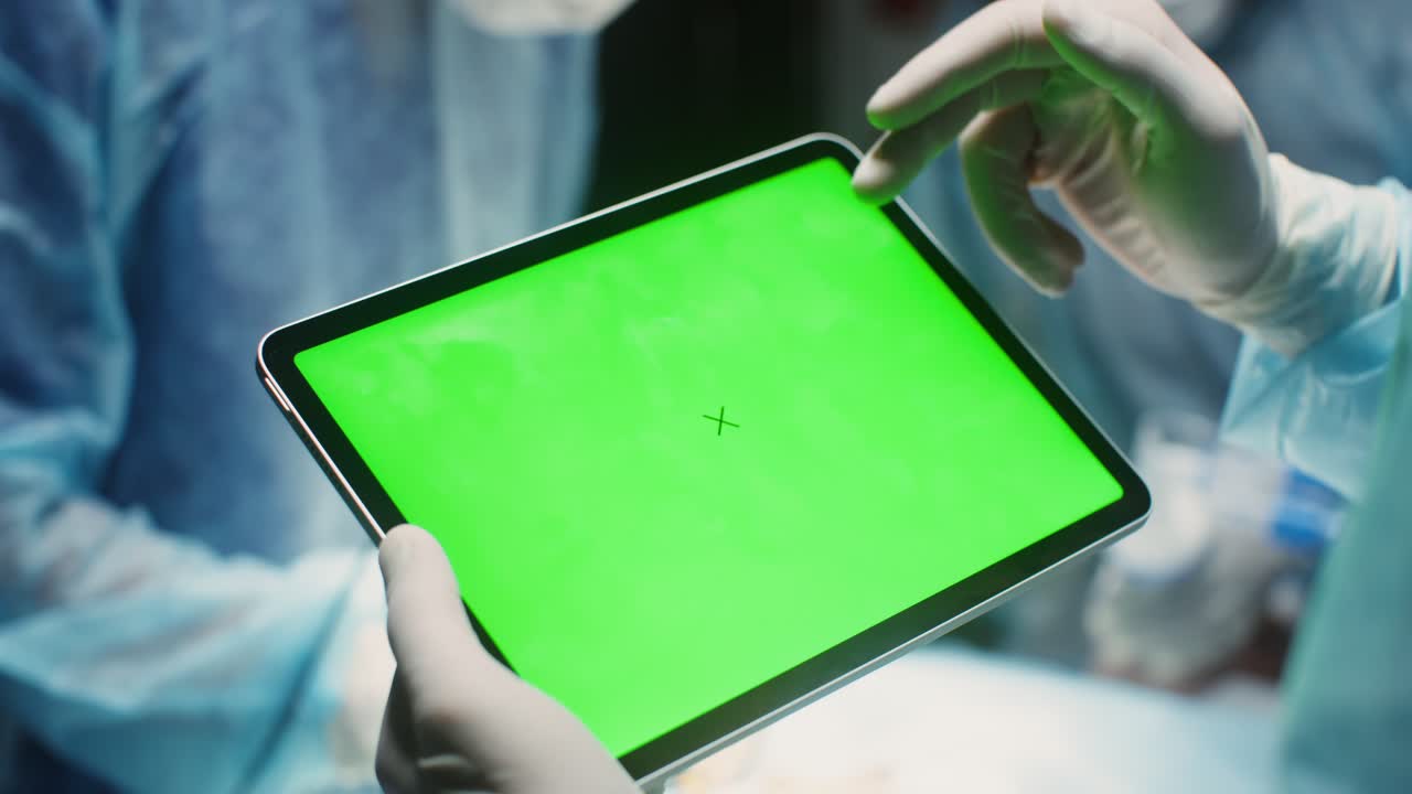 수술실에서 태블릿을 사용하는 외과 의사