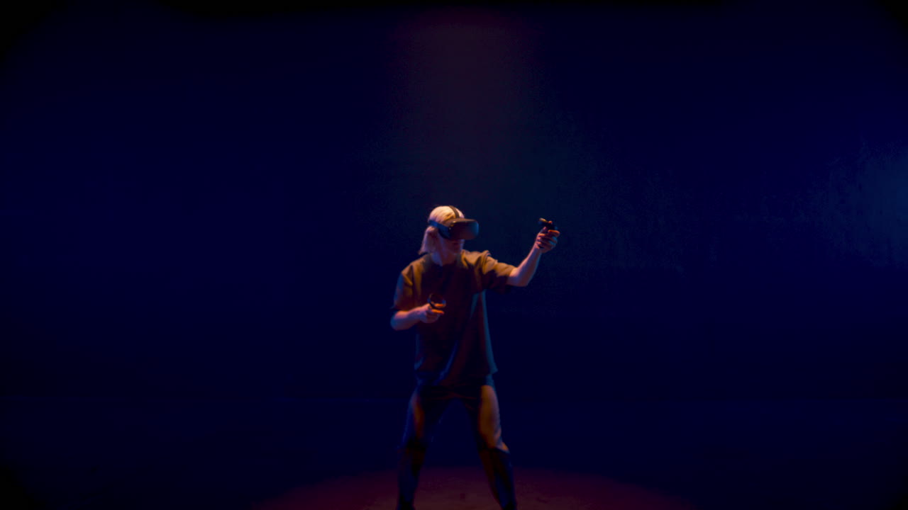 Energetic man playing vr game in neon cyberspace. Unknown player experiencing