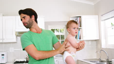 padre haciendo caras por la necesidad de cambiar el pañal del bebé