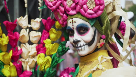A woman wears skull make up and traditional Mexican outfit at the Day of The Dead Parade in Mexico City. Slow motion shot with movement.