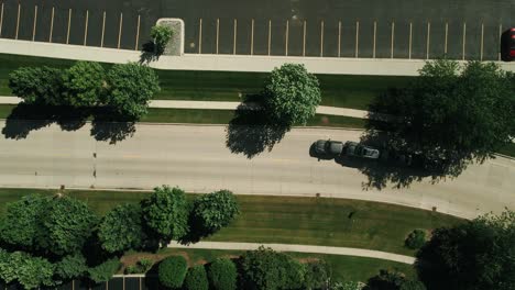 top-down-car-hauler-truck-driver-driving-with-3-cars-on-trailer-while-drone-is-following-4k