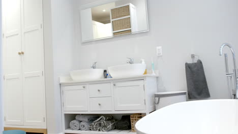 general view of bathroom with bathtub at home, mirror and washbasin, slow motion