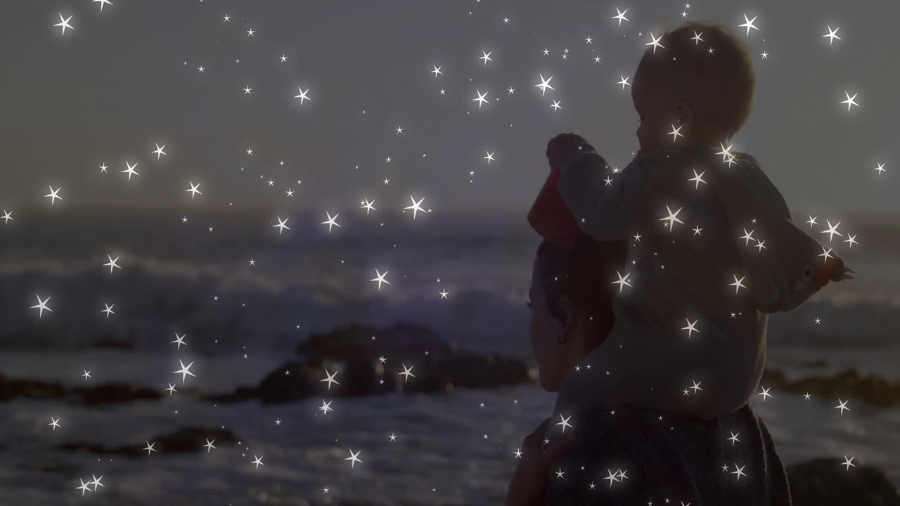 Mother carrying toddler on shoulders at beach sunset, with red bucket and star lights for health