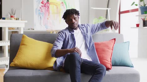 Portrait-of-african-american-male-artist-sitting-on-the-couch-at-art-studio