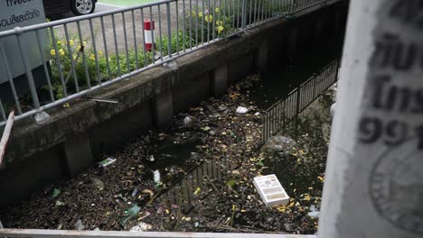 litter and mess in water in artificial canal in city