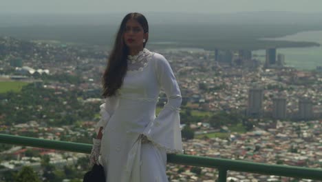 a youthful figure adorned in a vintage bridal outfit strolls along the walls of a fort.