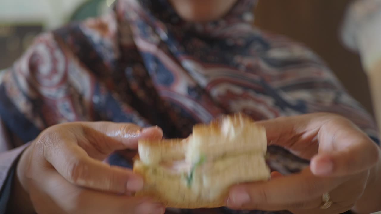 Una mujer comiendo un sándwich.