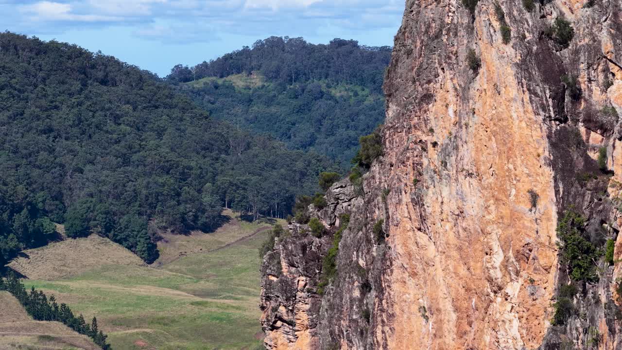 Drone footage captures Nimbin Rocks' rhyolite formations and lush eucalyptus forest under clear skies