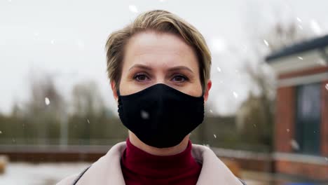 Woman-Wearing-Reusable-Protective-Mask-in-Winter.health,-safety-and-pandemic-concept-–-young-woman-wearing-black-face-protective-reusable-barrier-mask-outdoors-over-snow-in-winter