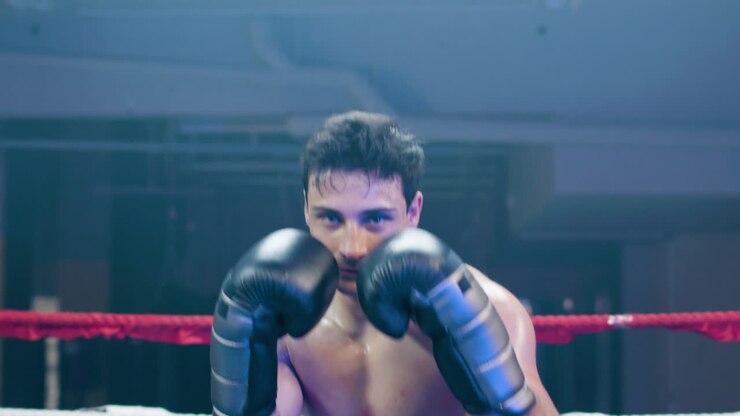 Giovane uomo attraente che fa shadow boxing verso la telecamera