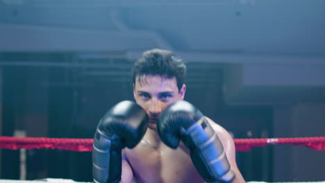 attractive young man doing shadow fight towards camera