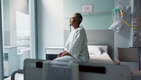 Sad,-patient-and-thinking-in-hospital-with-window