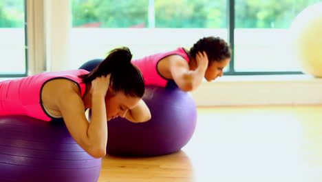 encantadoras mujeres enfocadas entrenando sus barrigas