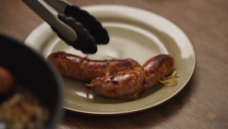 crop person serving sausages with onion on plate