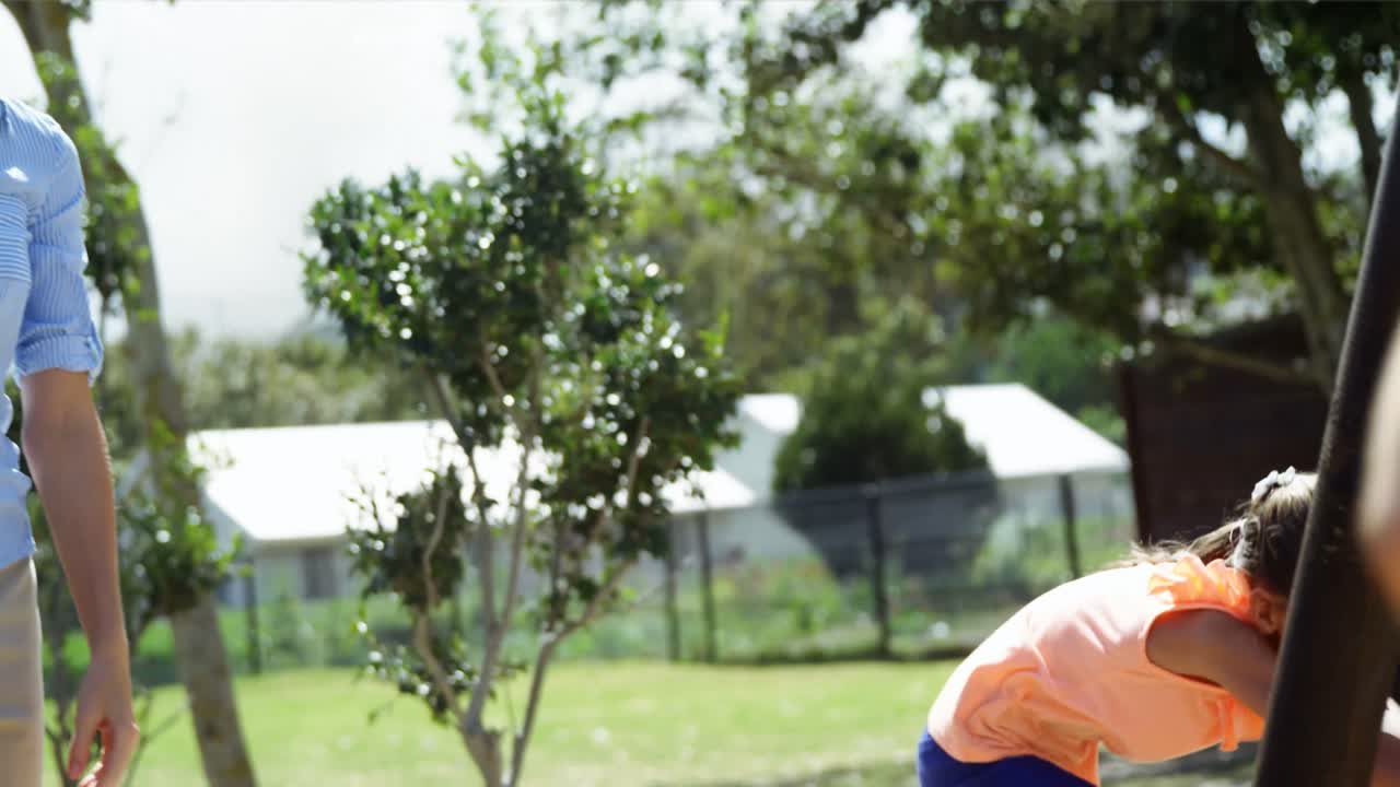 트레이너 와 학생 들 이 놀이터 에서 친구 들 을 스 ⁇  에 밀고 있다