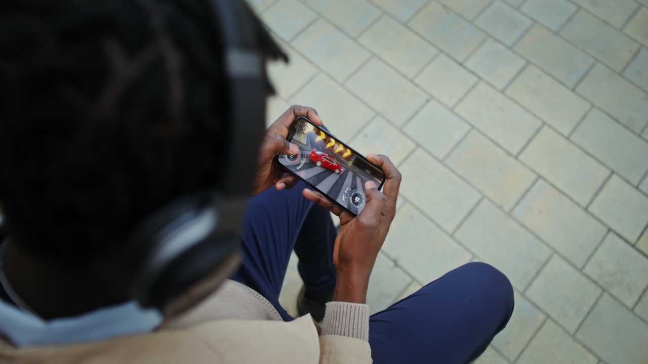 Man playing racing game on his phone
