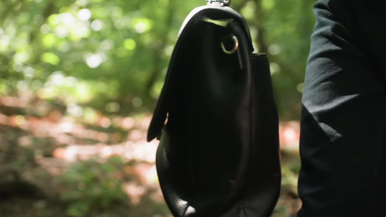 Smoky view of biologist in white shirt holding backpack while carefully moving through dense green forest under daylight, surrounded by trees and foliage, creating mysterious natural atmosphere