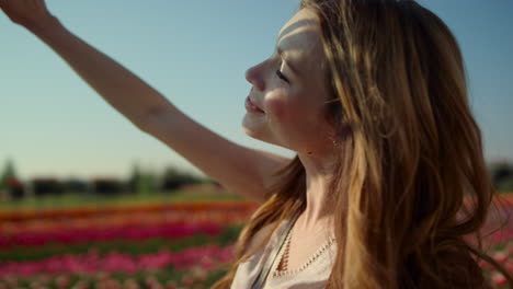 happy woman enjoying sun in garden. portrait of smiling girl making sun shadows.