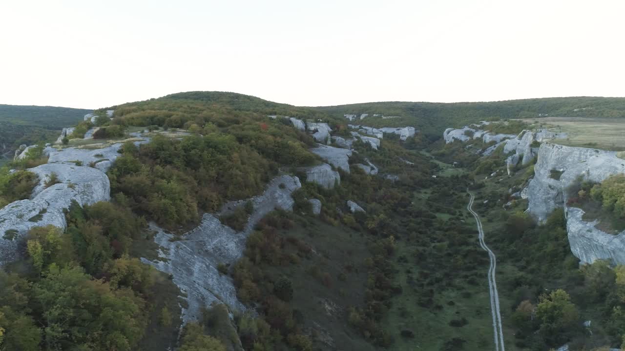 vista aérea de un valle de montaña con acantilados y bosques