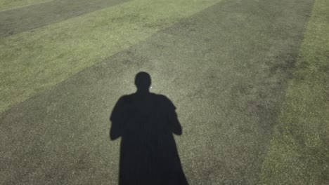 POV-Eines-Mannes,-Der-An-Einem-Sonnigen-Tag-Dem-Schatten-Auf-Dem-Fußballplatz-Folgt