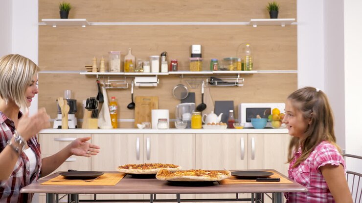 Persone che mangiano la pizza in cucina