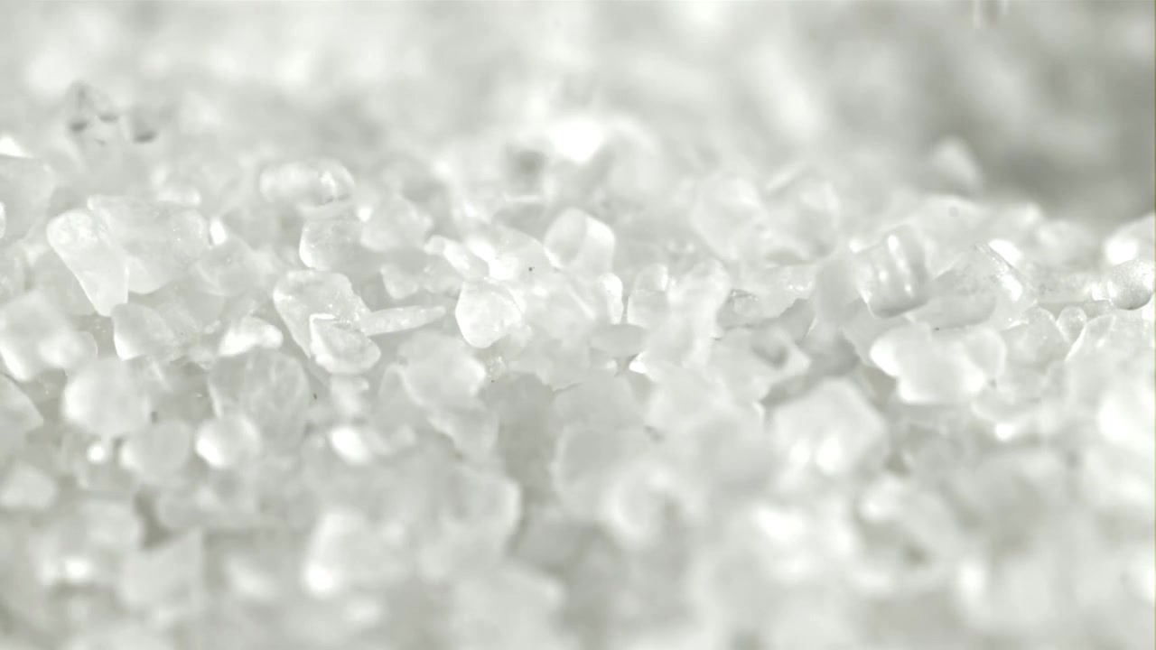 Macro di cristalli bianchi di sale o zucchero che cadono