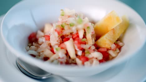 Close-Up-of-Fish-Bowl-with-Mango-Slices,-Tropical-Dining-Experience