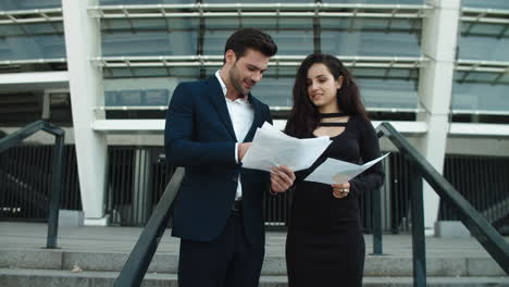 young business couple analyzing documents outside