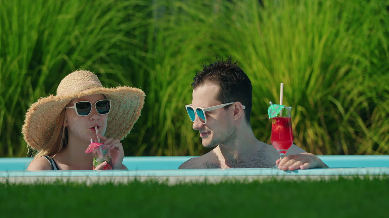 Paar genießt Cocktails am Pool