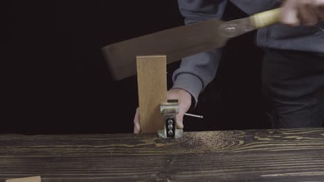 a wood craftsman sawing a wooden detail to make a beard comb. carpenter makes a handmade wooden comb. . cinema 4k video