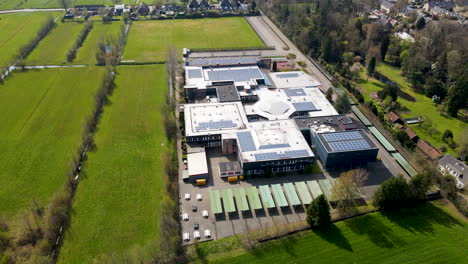 aerial of large high school surrounded by green meadows