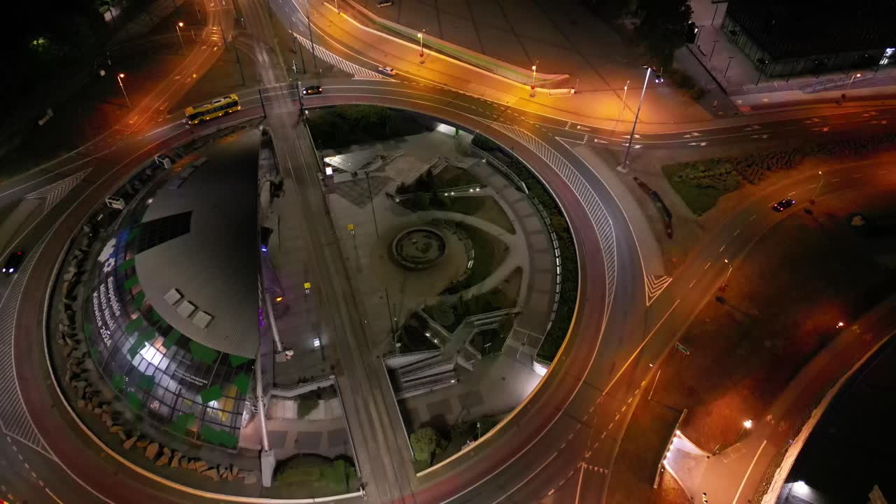 tráfico nocturno en la ciudad de katowice - intersección de rotonda iluminada, vista de dron 4k