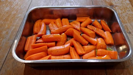 oil drizzled on peeled, cut and seasoned carrots ready for roasting