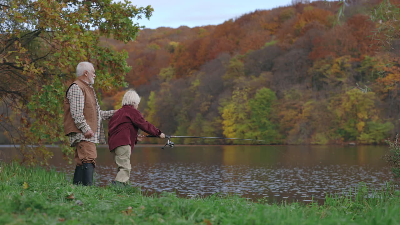 Grandfather and Grandson Fishing by a Lake in Autumn