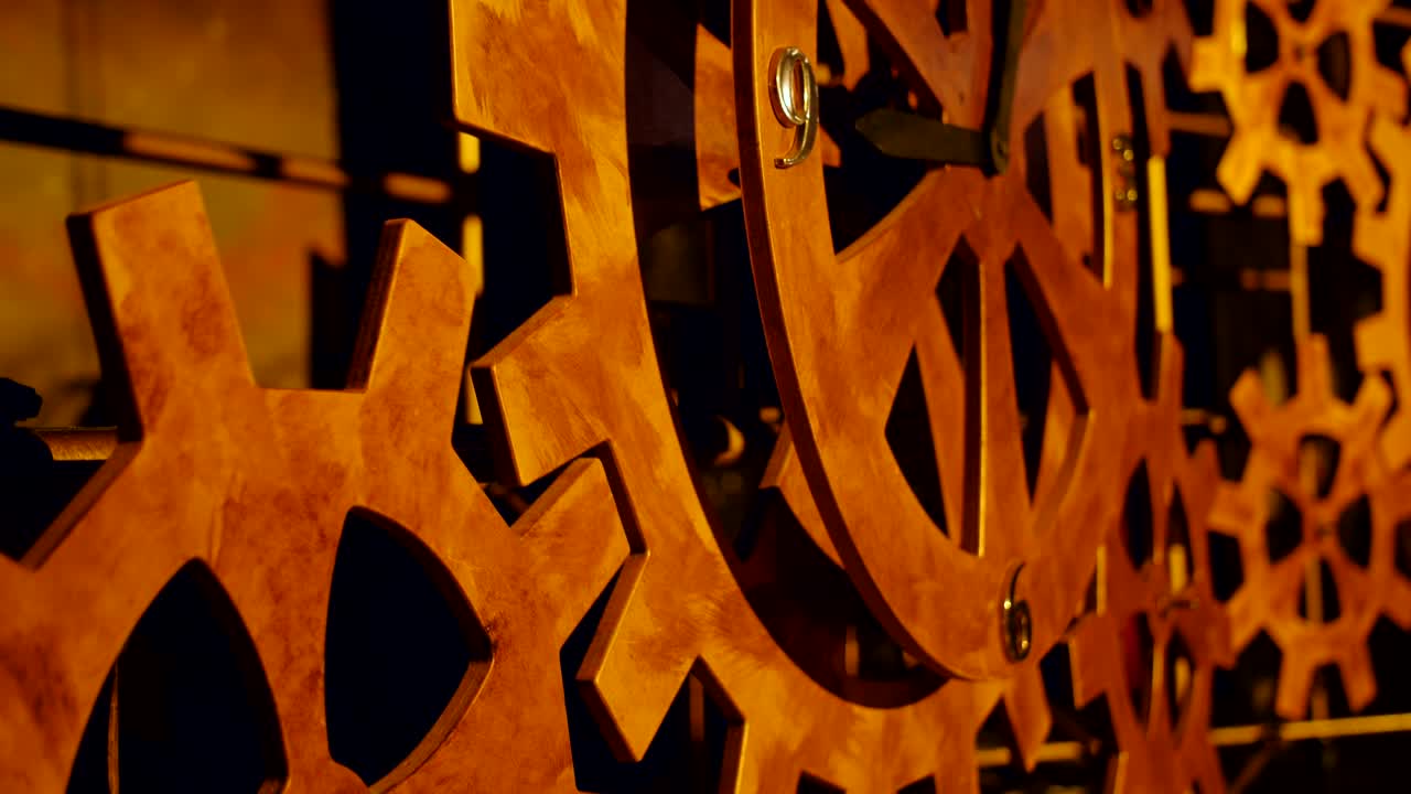 A lot of rotating wooden gears in a huge clock mechanism.