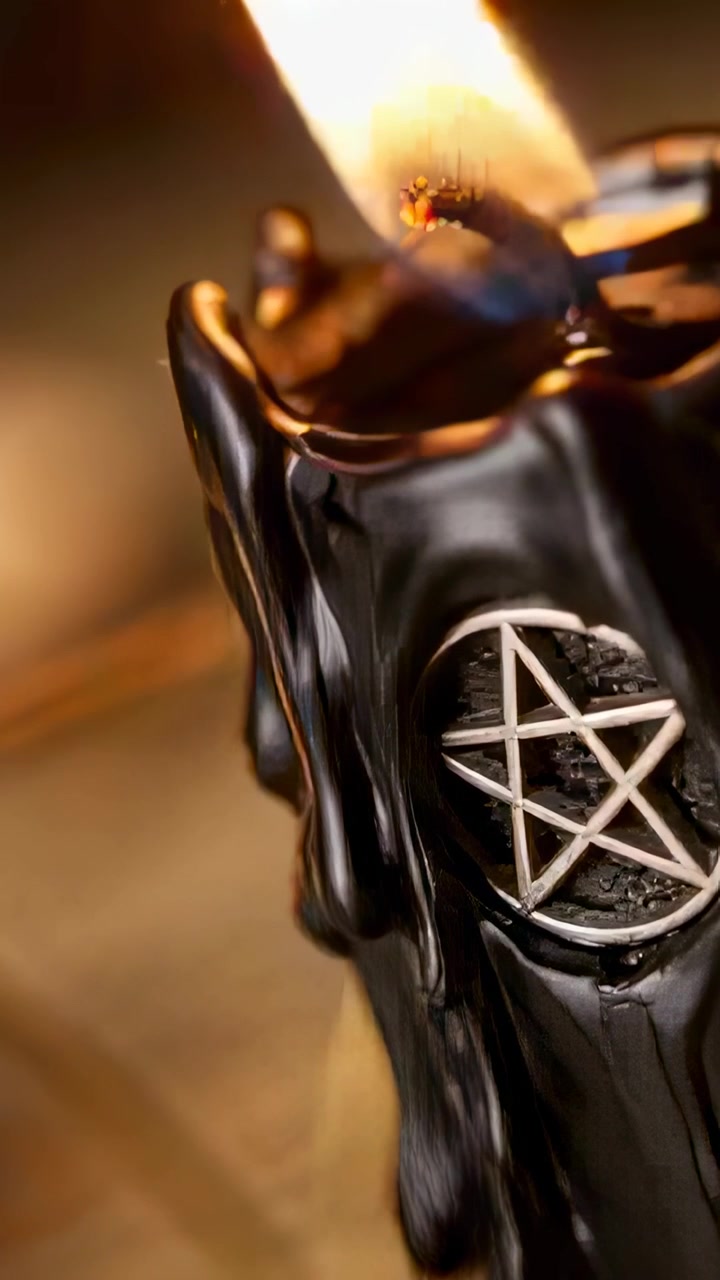 Vertikal video: Flakkende svart vokslys med pentagram-anheng, tent veke smelter i nærbilde, med plass til tekst.