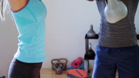 coach assisting a woman to exercise with kettlebell 4k