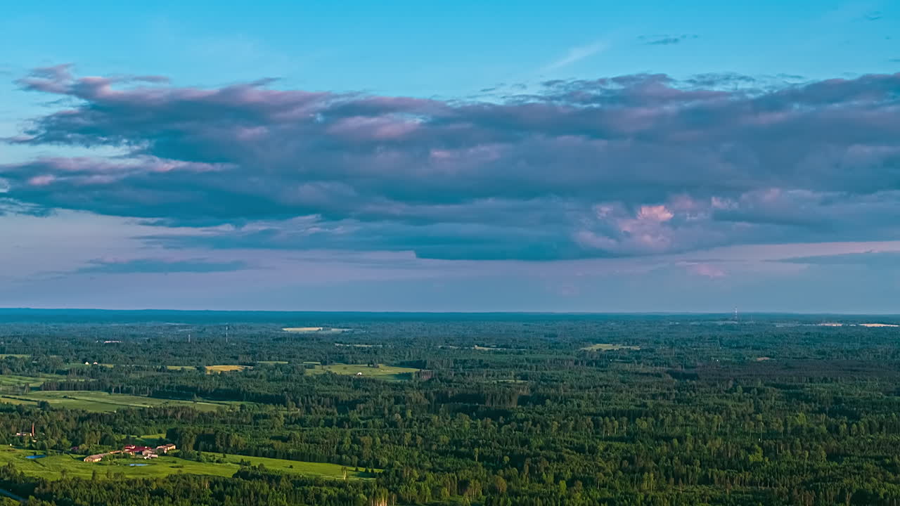 Thin layer of clouds above forest flat rural landscape countryside, time lapse