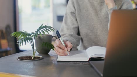 woman taking notes at a cafe