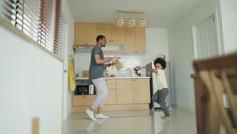 happy relaxed black african american father and his little afro boy dancing