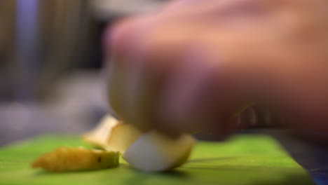 Close-up-of-hands-slicing-a-pear-on-a-green-cutting-board