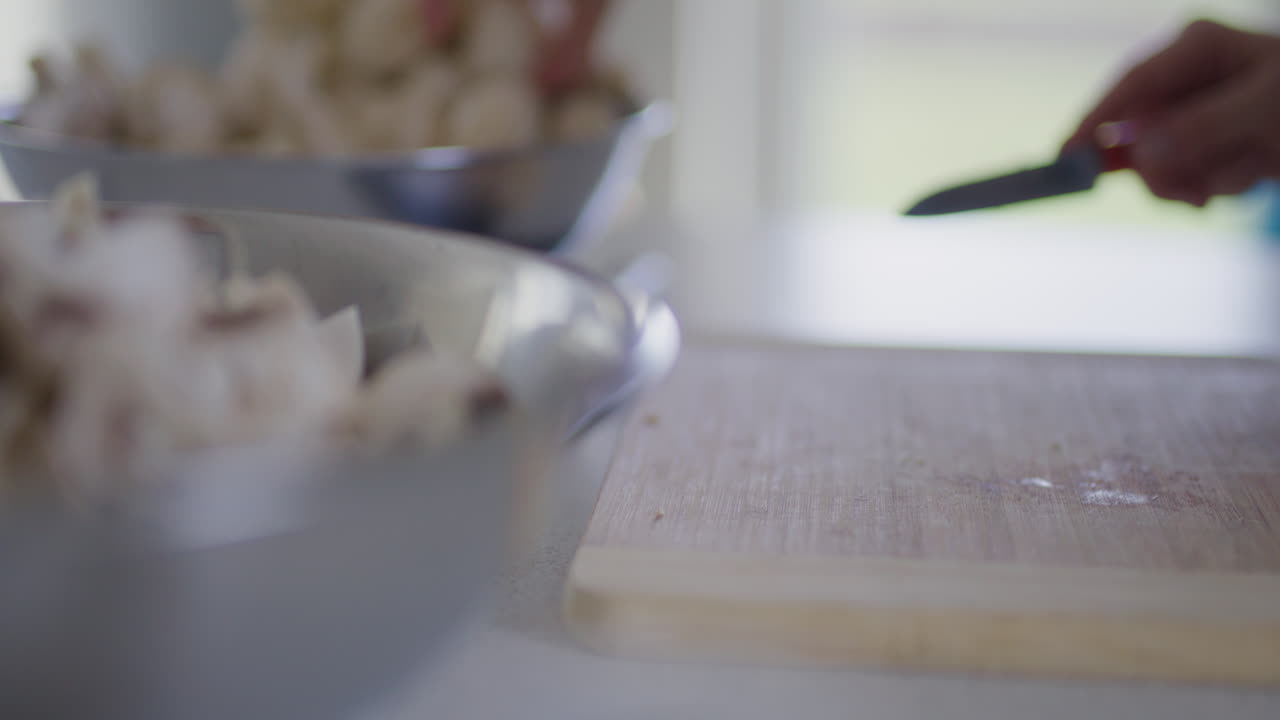 Primo piano delle mani dello chef che affettano i funghi