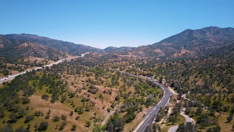 Paneo-Aéreo-Sobre-El-Paso-De-Tehachapi-Ferrocarril-Y-Automóviles-En-La-Autopista-En-California