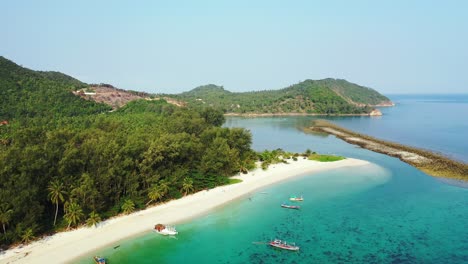 thailand, aerial - pristine nature, white sand beach, palm trees and turquoise seawater with boats