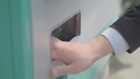 hand of business person withdrawing coins from an atm in frankfurt, germany