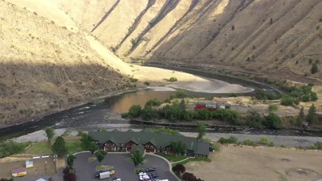 the salmon rapids lodge in riggins idaho, is a popular hotel on us 95. drone tracking shot with salmon river behind the lodge.